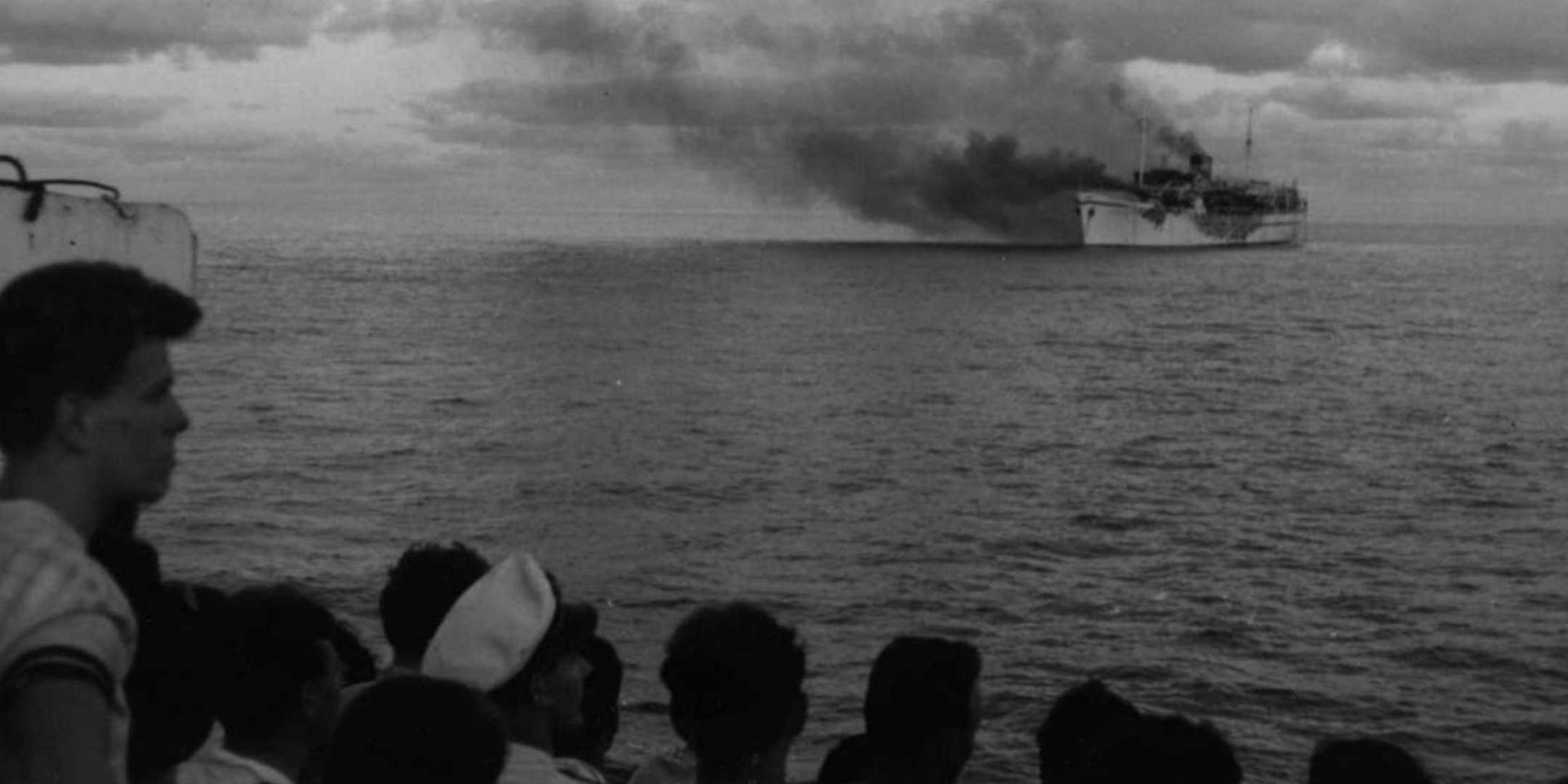 Passengers watch from the deck of City of Sydney as Skaubryn burns in the Indian Ocean, 1958. ANMM Collection Gift from Barbara Alysen ANMS0214[005]. Reproduced courtesy International Organisation for Migration