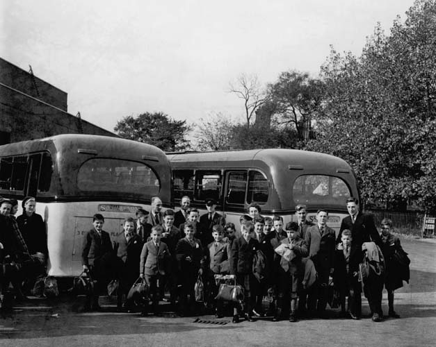 Jim Stone (sixth from right, holding parcel of cakes) on departure from Thurlby House in Woodford Bridge, Essex, UK, 1947. Reproduced courtesy Jim Stone.