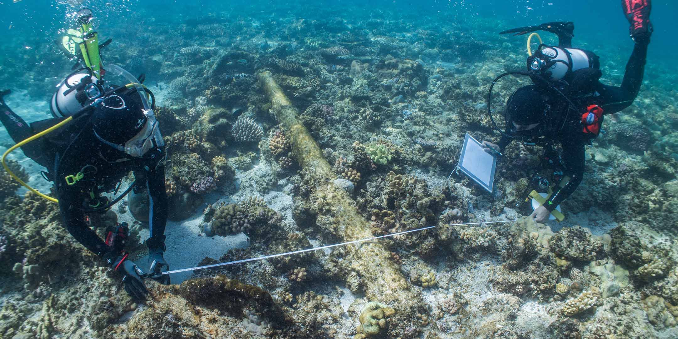 : The author (right) and Irini Malliaros from the Silentworld Foundation use ‘old school’ methods to obtain measurements of the Admiralty Old Pattern Long-Shanked Anchor found in the shallows at Boot Reef. Image: Julia Sumerling/Silentworld Foundation. 
