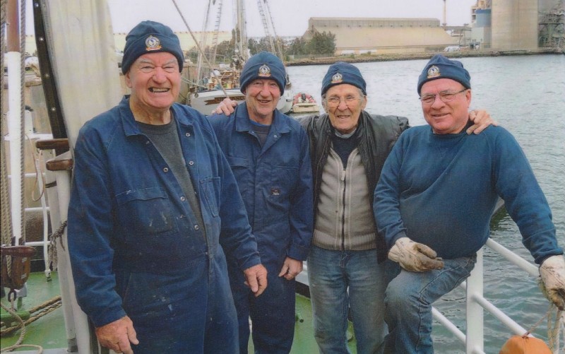 Four men standing together on a boat