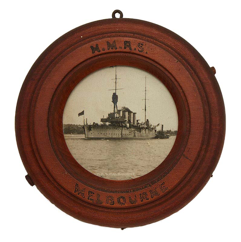 Black and white photograph of HMAS MELBOURNE (I) in a circular wooden frame inscribed 'HMAS MELBOURNE'