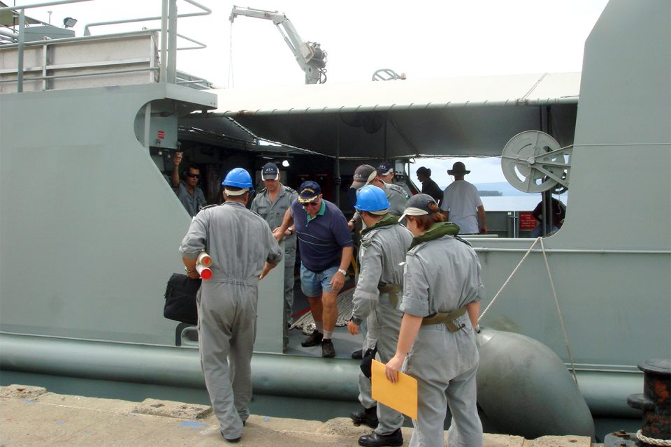 Commander John Foster, RAN (centre) disembarking from the Royal Australian Navy’s survey motor launch HMAS Benalla, 27 February 2007. Foster directed efforts to locate AE1 between the 1970s and his death in 2010. Photographer: Gus Mellon/Find AE1 Ltd.