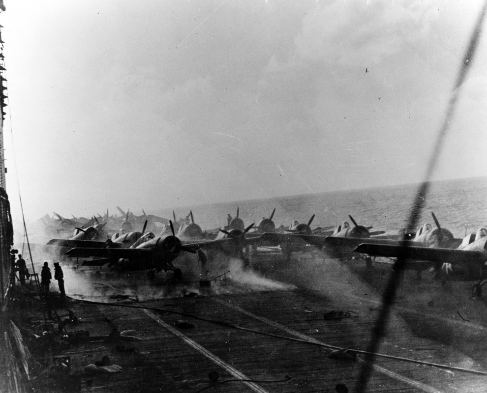View on the flight deck of USS <em>Lexington</em>  on 8 May 1942, during the Battle of the Coral Sea. Smoke is rising around the after aircraft elevator from fires burning in the hangar. Image: Official US Navy photograph collection of the National Archives, Naval History and Heritage Command BD-G-16802.