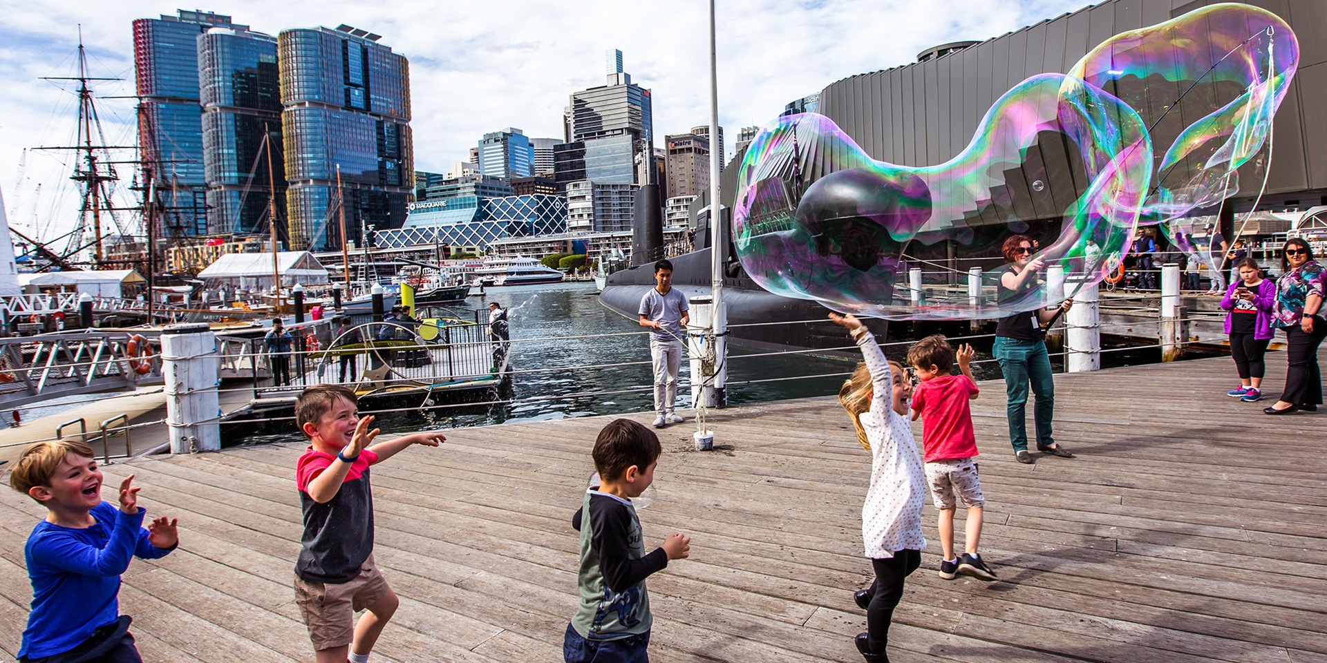 A group of children playing with giant bubbles on the museum's performance platform