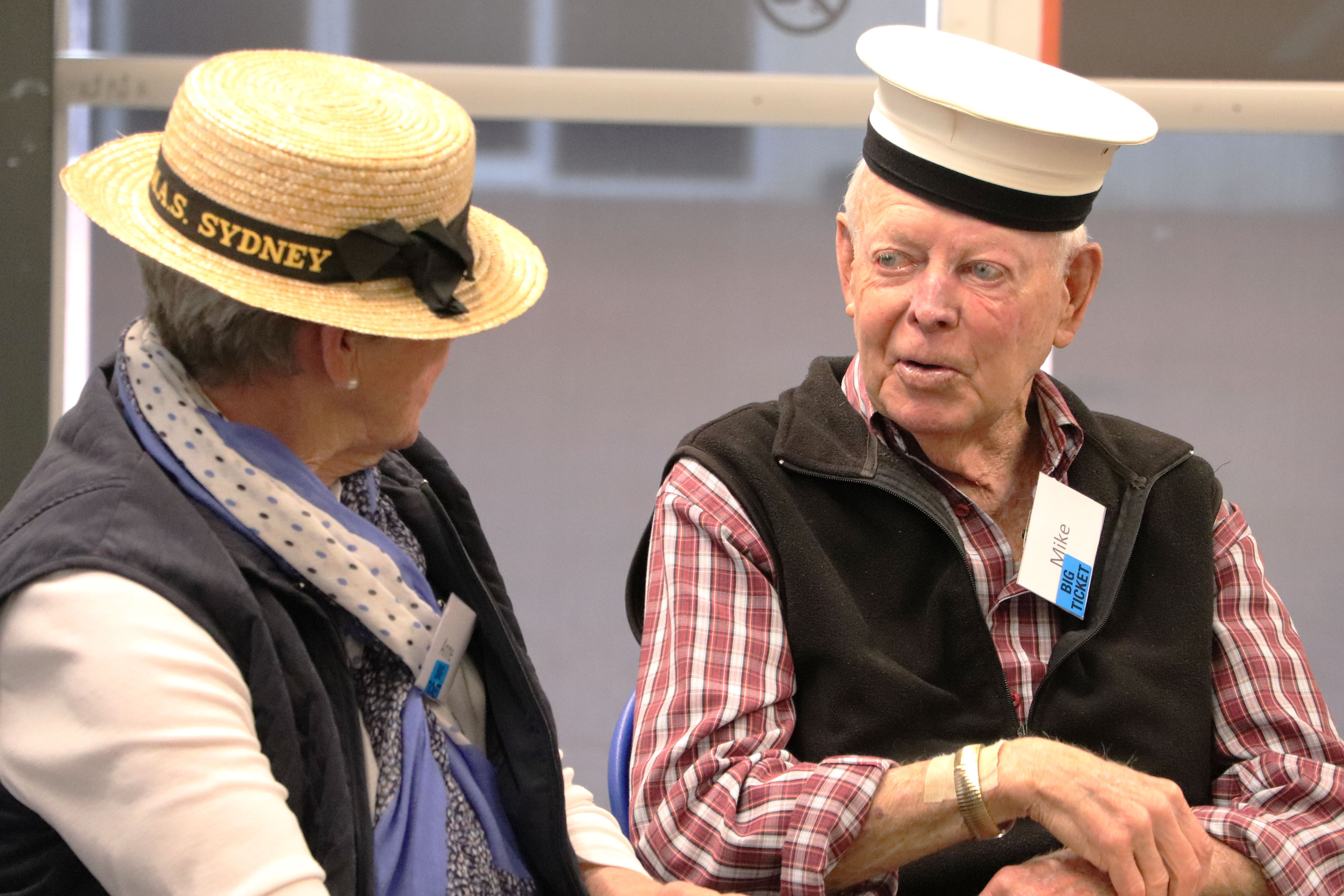 Two elderly visitors wearing nautical hats