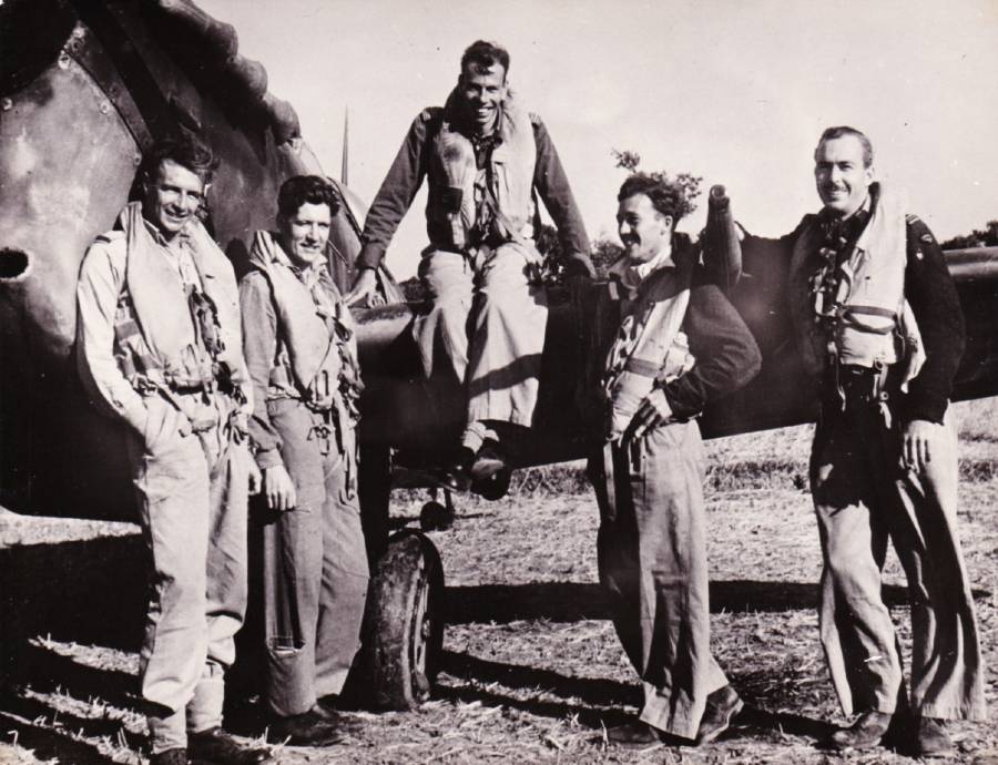 Five spitfire pilots from No. 136 Squadron RAF and RAAF after shooting down 15 Japanese aircraft in one day in 1944. Squadron Leader Noel Constantine is seated on the wing of his aircraft. Image: Private collection of Noel and Geoff Constantine, and Interservices Public Relations Directorate, India, Pen 547.