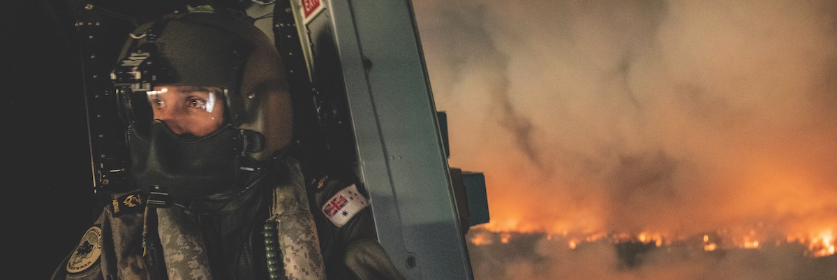 Royal Australian Navy Aircrewman Leading Seaman Ben Nixon of 808 Squadron assesses the Tianjara fire in the Moreton and Jerrawangala national parks out of an MRH-90 Taipan Military Support Helicopter. Photographer CPOIS Kelvin Hockey, image courtesy RAN. Image series S20193355